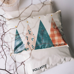 Close up shot of a cream Better Packaging POLLAST!C Christmas mailer with geometric Christmas trees