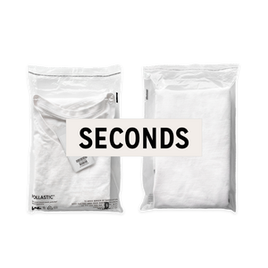 Front and back of a transparent Better Packaging POLLAST!C poly garment bag, containing a white tee shirt with graphic label "Seconds" over it on a transparent background